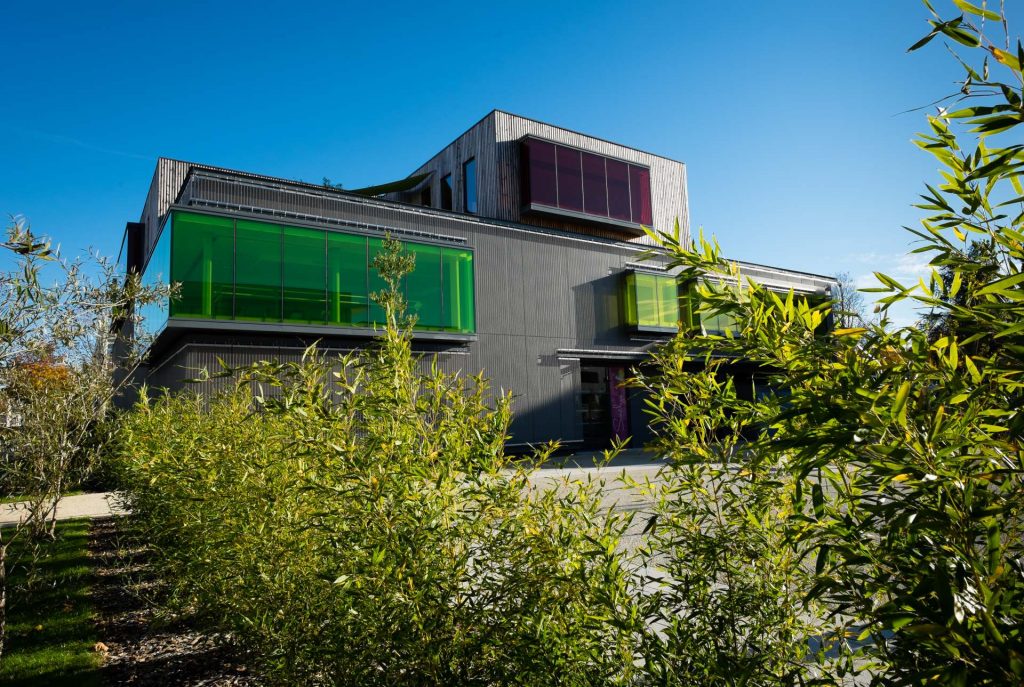 bâtiment moderne, Soëlys, vitres teintées, jaunes, vertes, arbres, ciel bleu