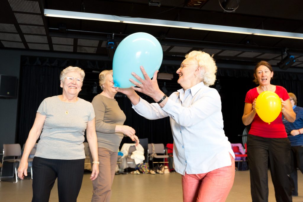 ateliers forme, une dame âgée tient un ballon bleu dans ses mains