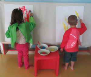 Une petite fille et un petit garçon en train de peindre