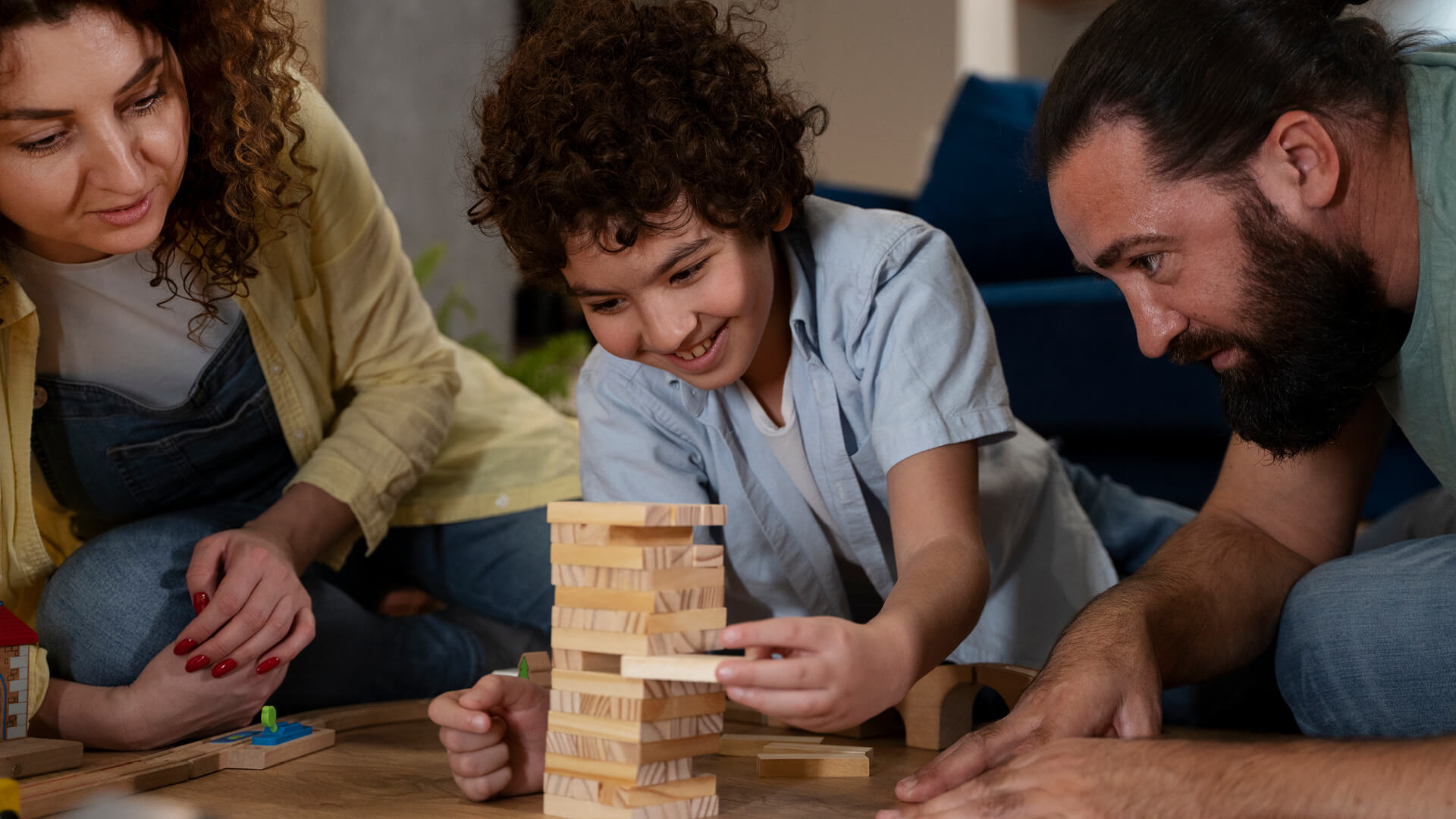 petit garçon, mère et père jouant à un jeu de société